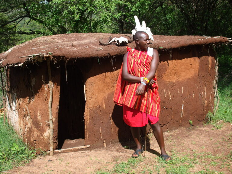 Masai Mara Massaidorf Mann vor Hütte